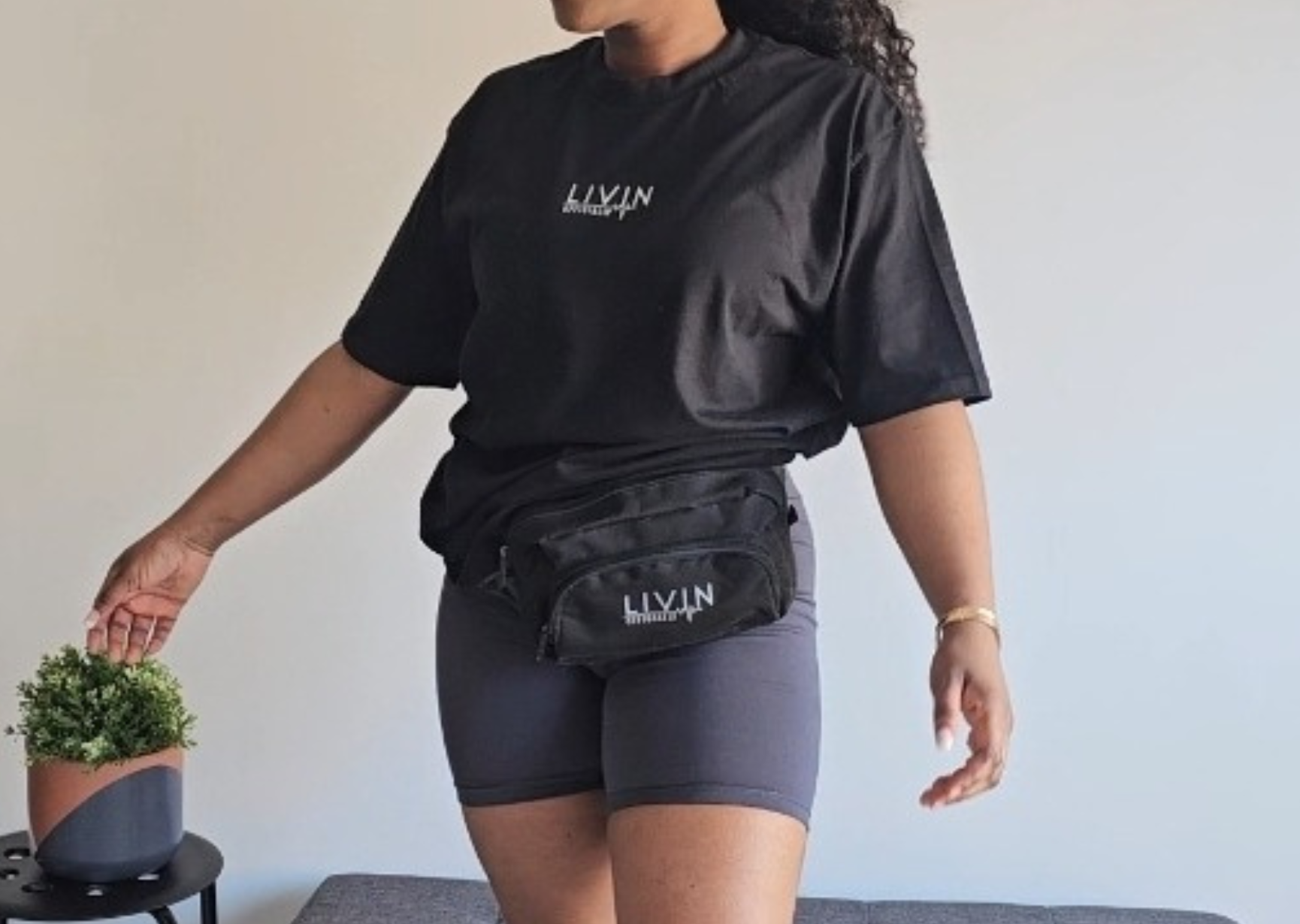 model wearing waist bag with oversized tshirt and biker short set, strolling around Nottinghill carnival 